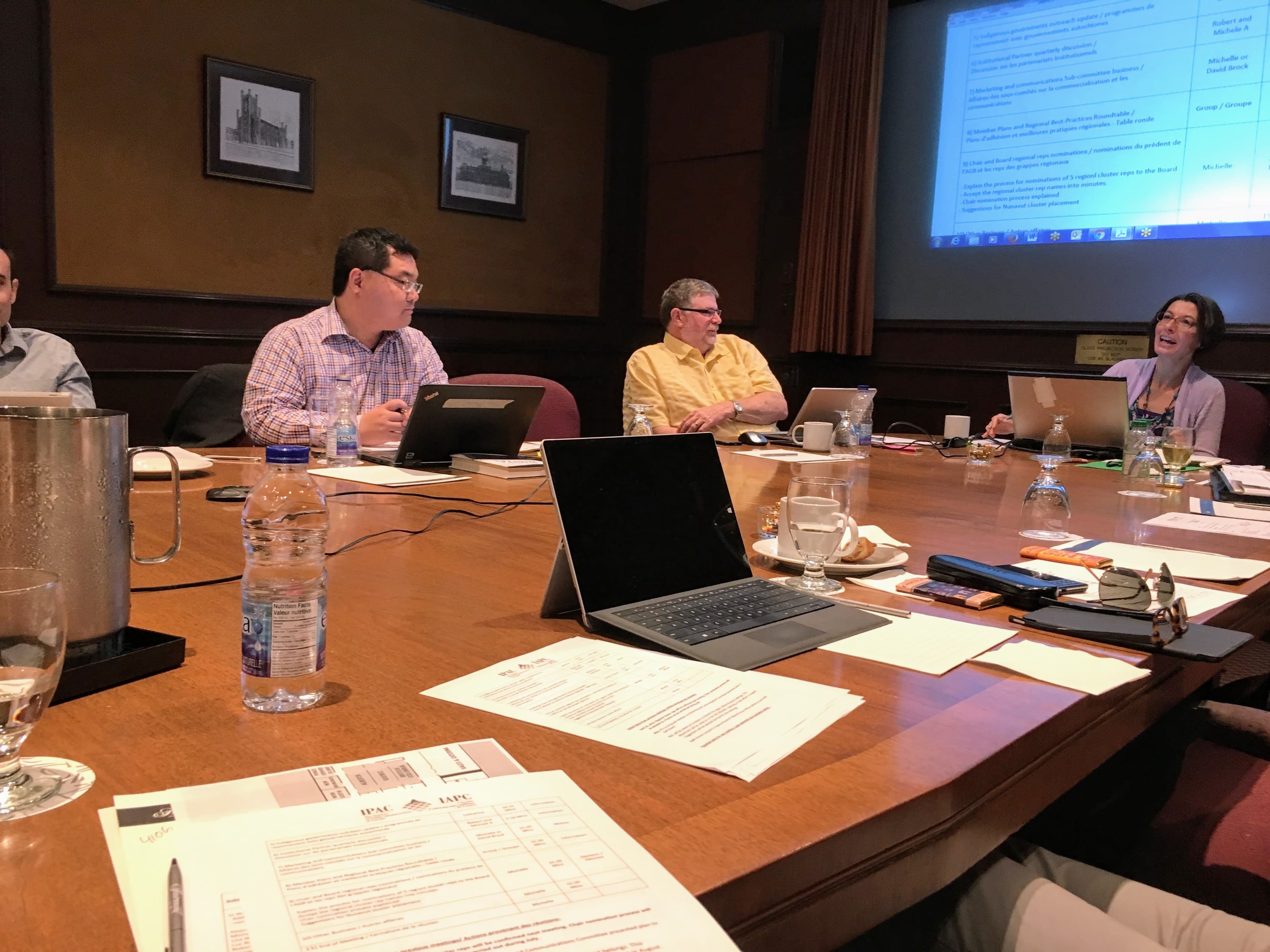 A facilitated meeting around a conference table with discussion materials visible.
