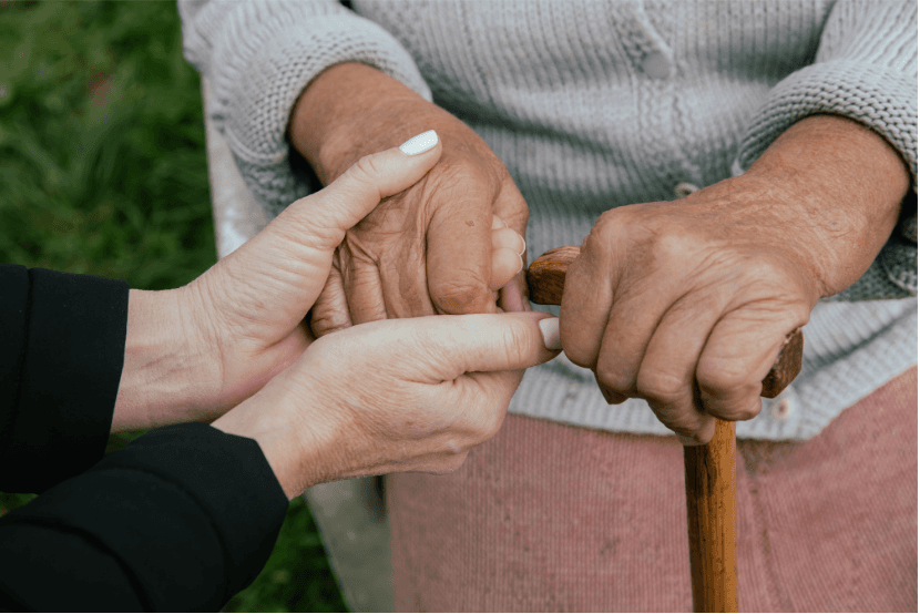 Elders holding hands lovingly.